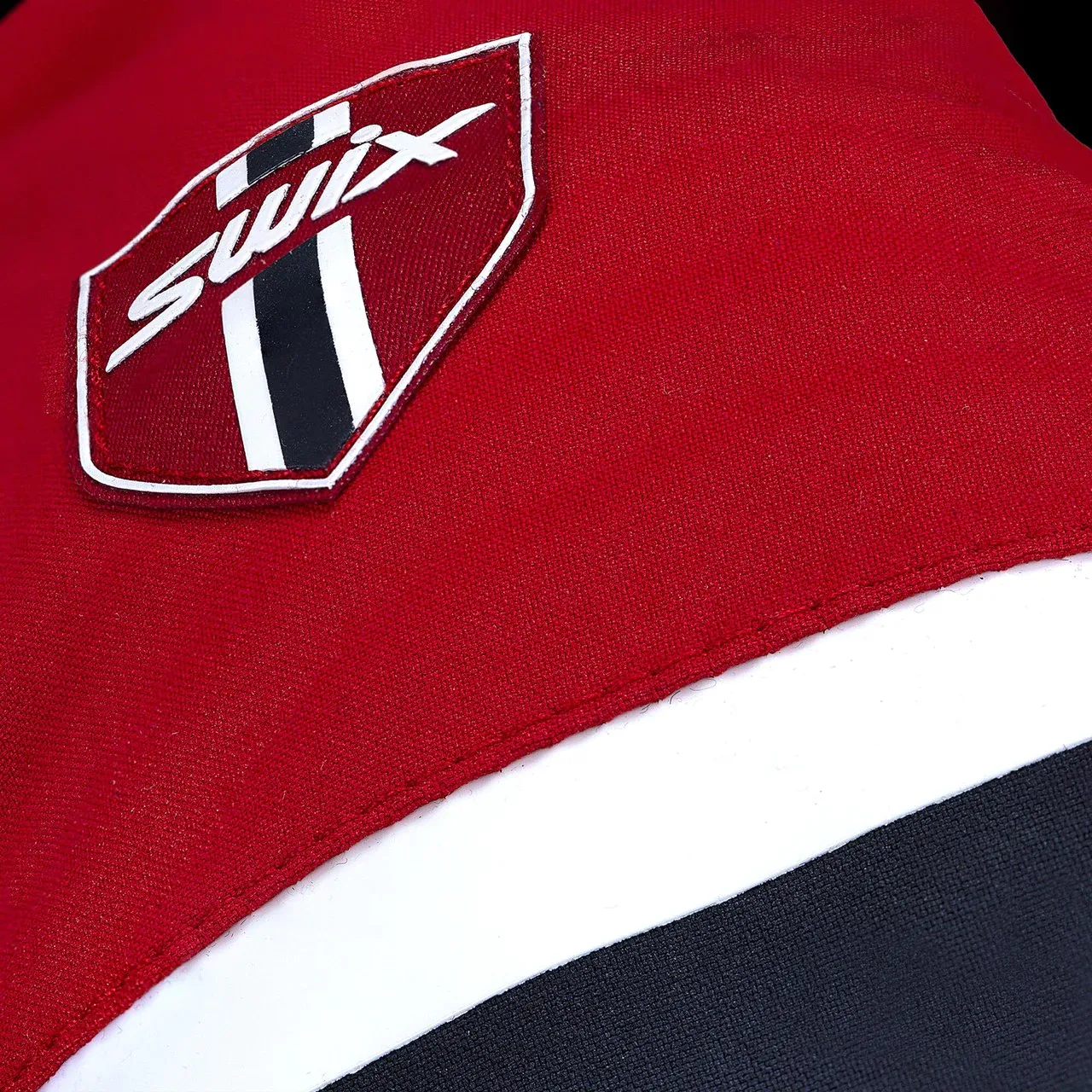 Close-up of a red fabric with a Swix logo on a black and white background