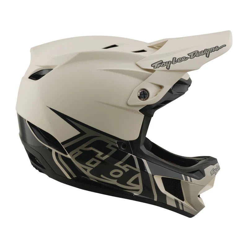 Beige and black motorcycle helmet with Troy Lee Designs branding on a white background