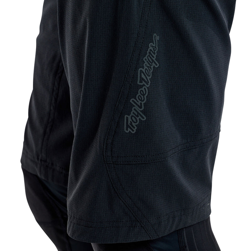 Black shorts with a brand logo on the sleeve against a white background