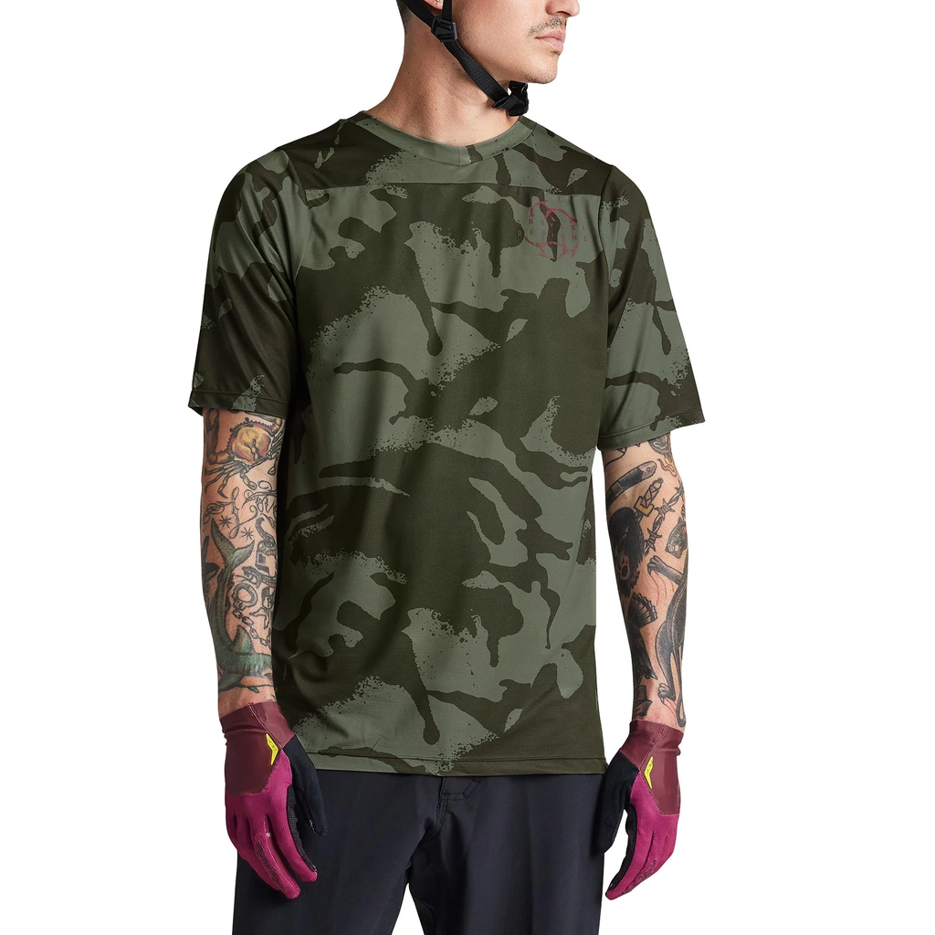 Person wearing a camouflage t-shirt and gloves on a white background