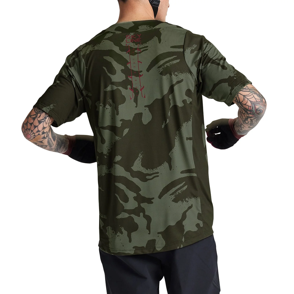 Person wearing a green camouflage t-shirt on a white background