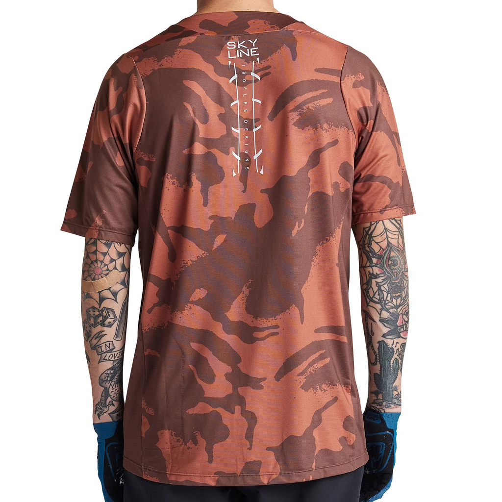 Camouflage-patterned shirt with visible branding on a white background