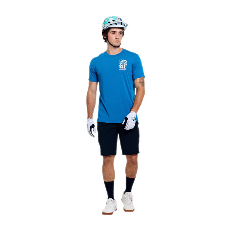 Person wearing a blue cycling jersey, black shorts, gloves, and a helmet on a white background