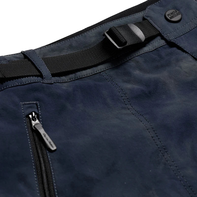 Close-up of navy blue pants with a black belt and zipper detail on a white background