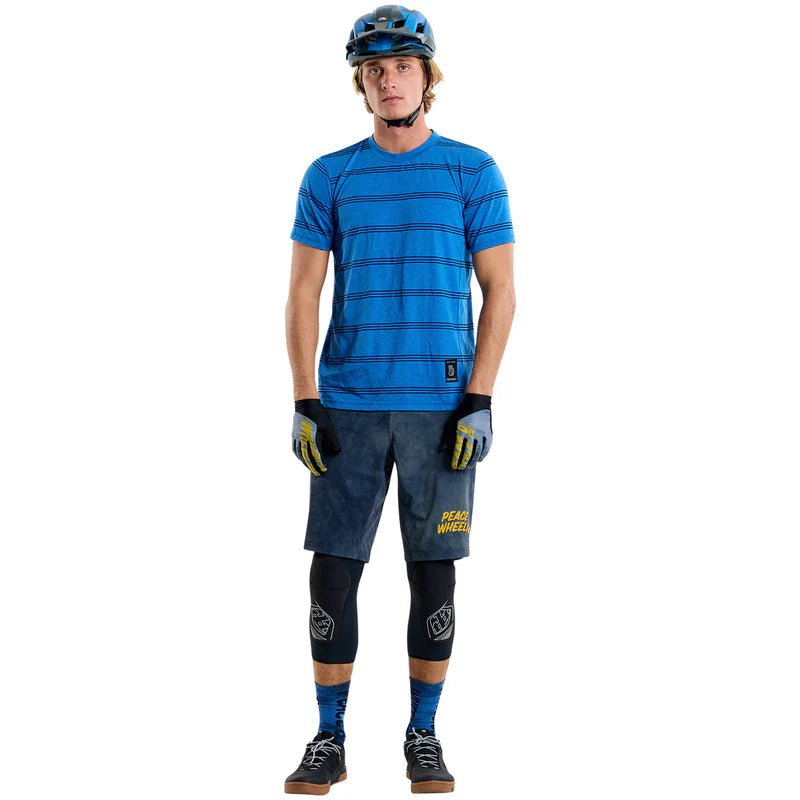 Person wearing blue cycling outfit with helmet and gloves on a white background