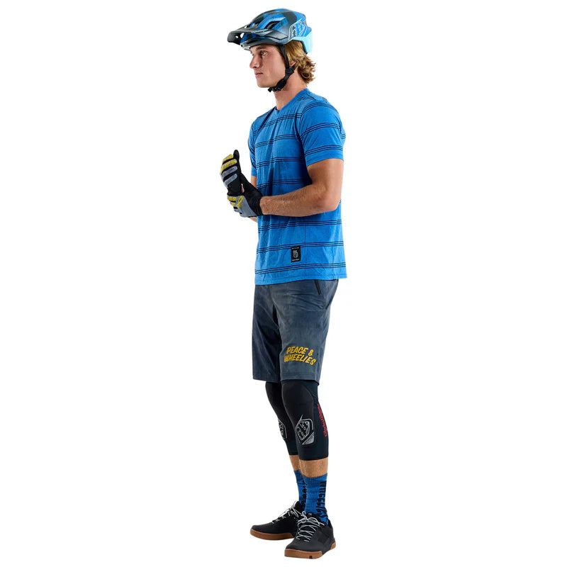 Person wearing a blue jersey and gray pants with a helmet on a white background