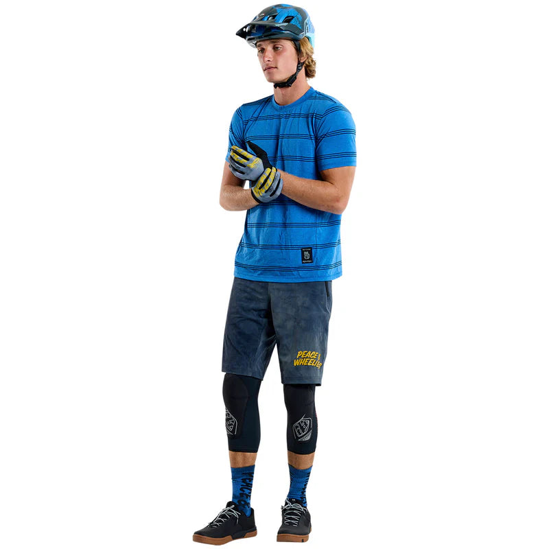 Person wearing a blue and gray athletic outfit with protective gear on a white background