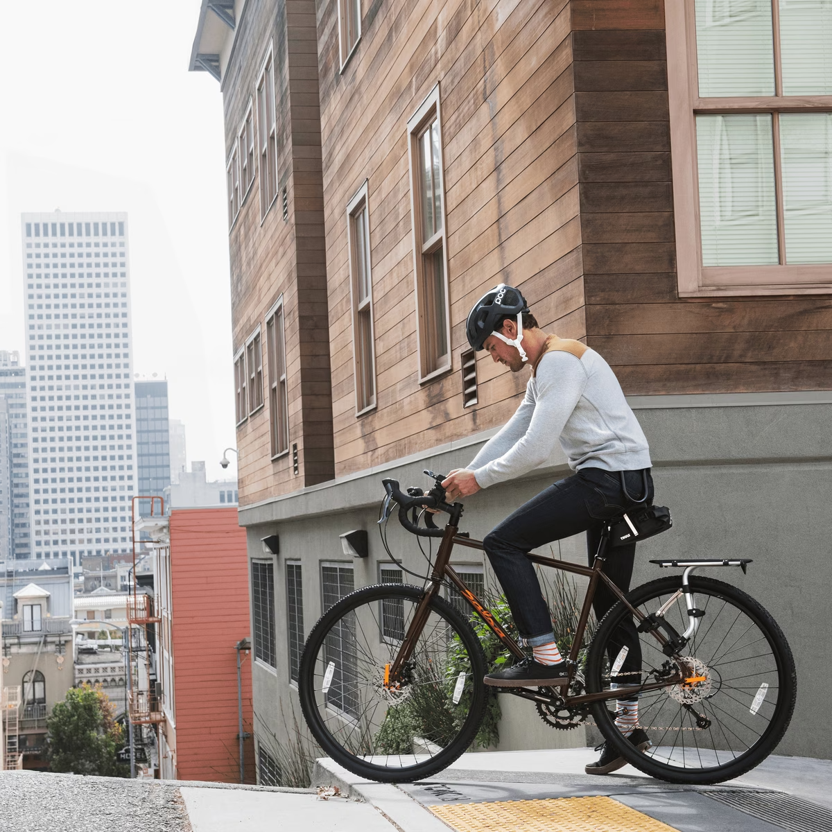 Person on a bicycle in an urban setting with tall buildings in the background