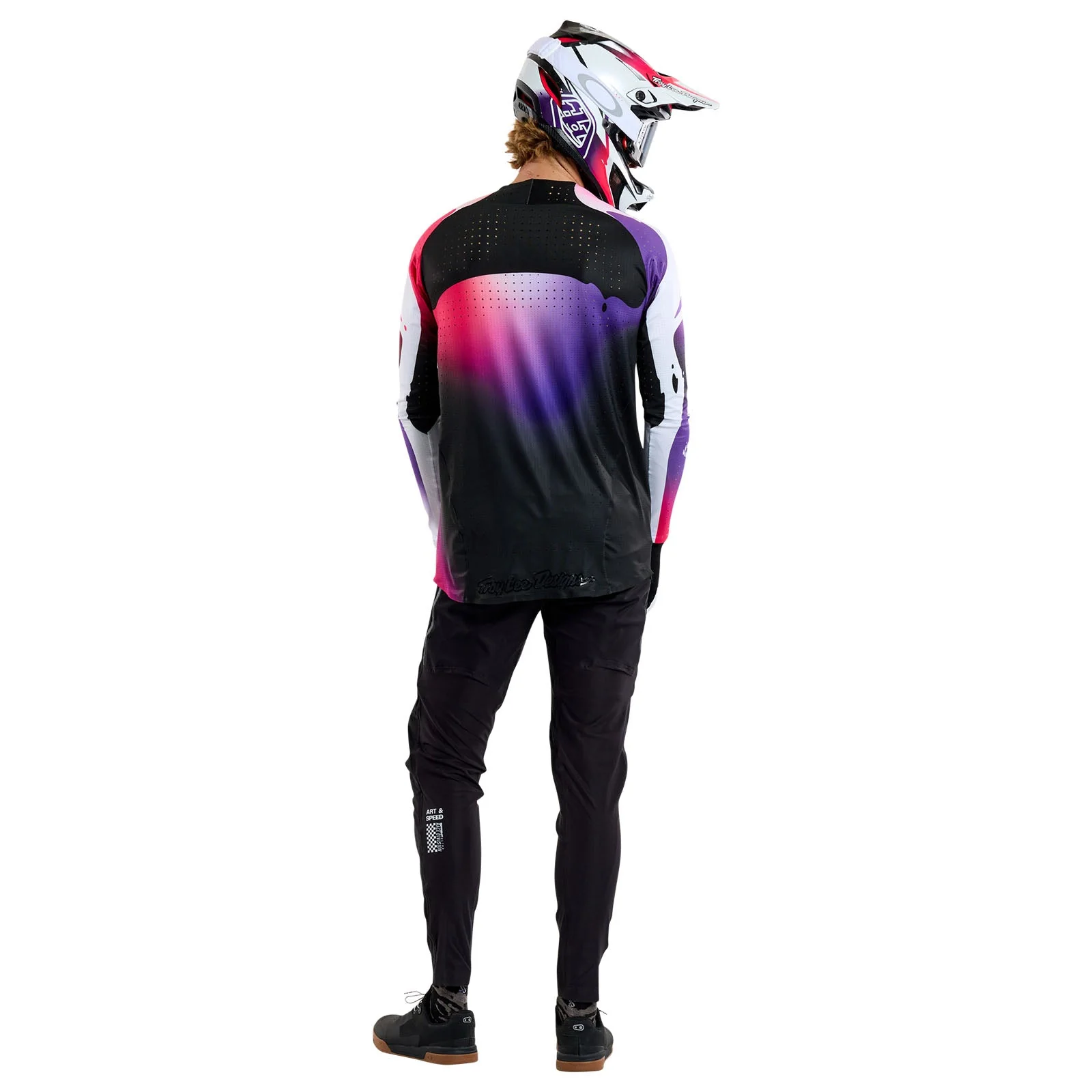 Person wearing a black, purple, and white mountain biking outfit with a helmet on a white background
