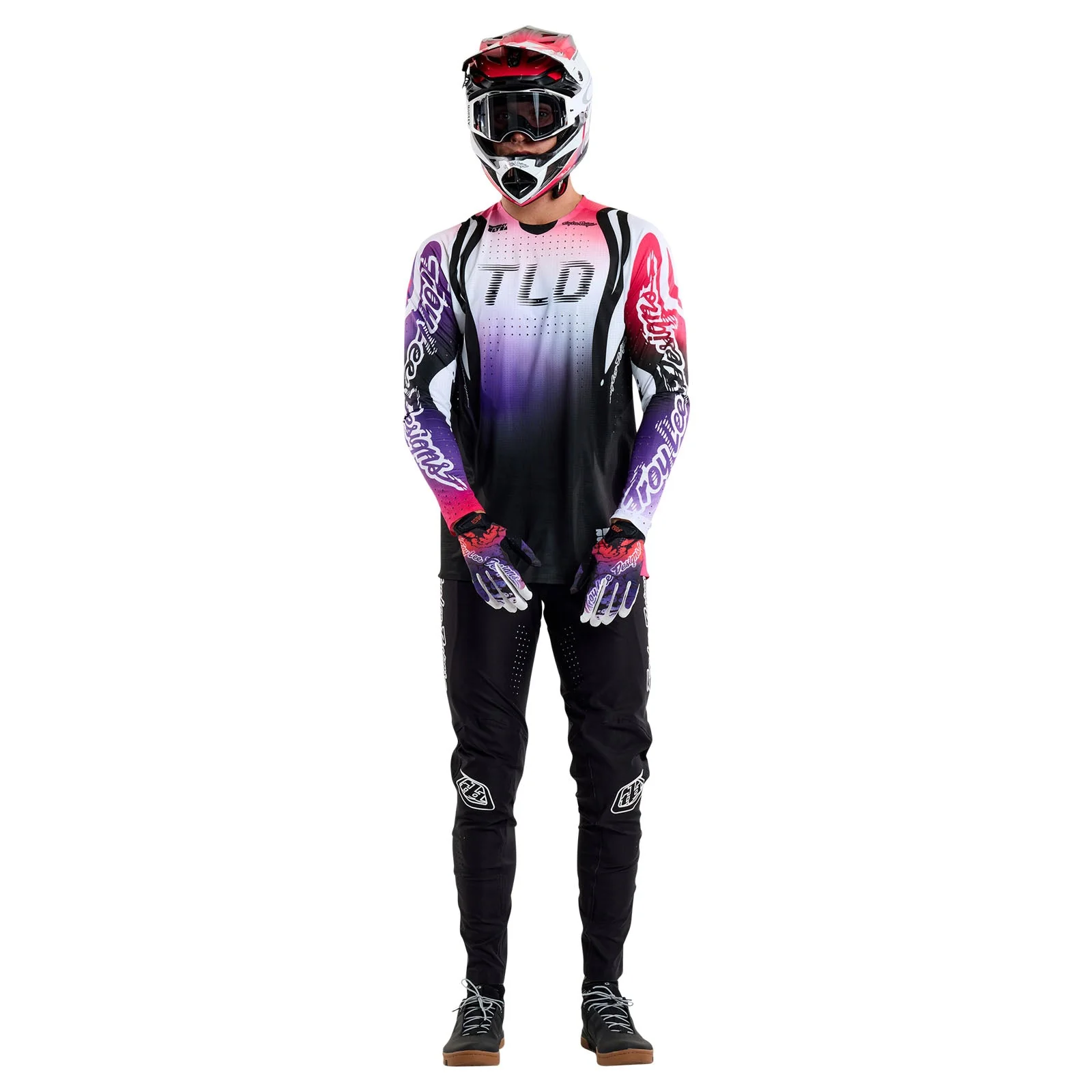 Person wearing a gradient mountain biking outfit with 'TLD' branding on a white background