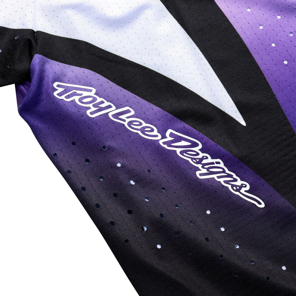 Close-up of a Troy Lee Designs jersey with purple and black colors.