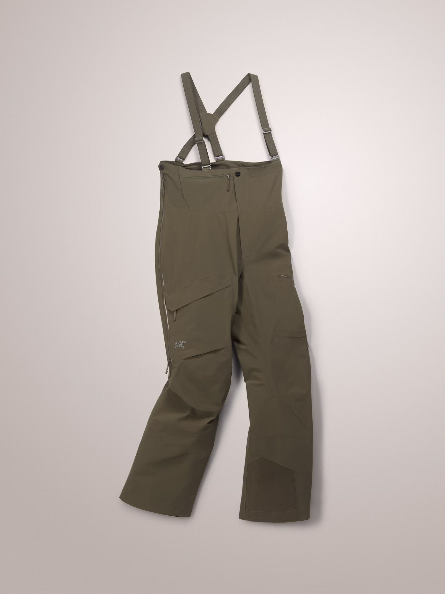 Green bib overalls with suspenders on a light gray background