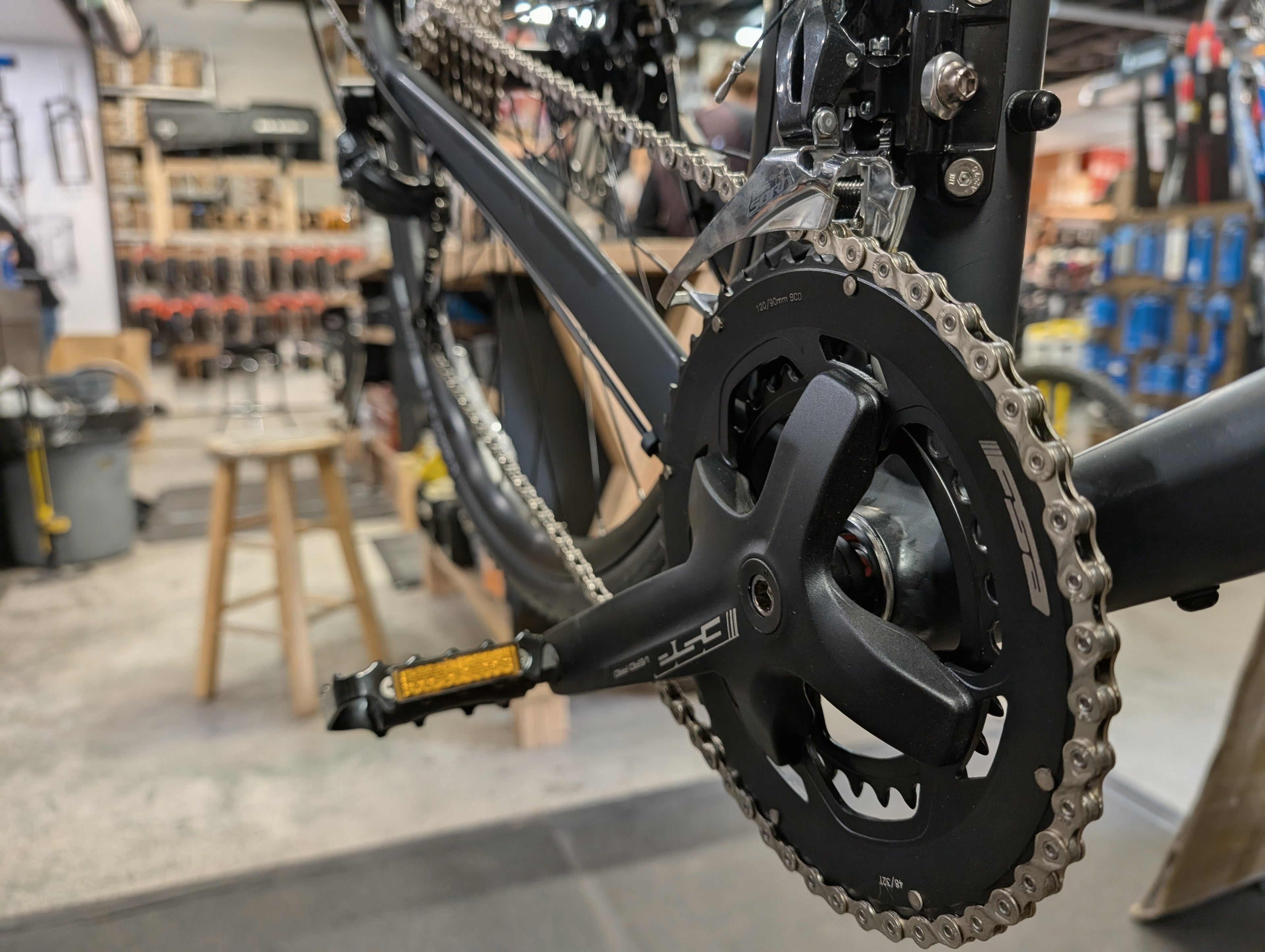 Close-up of a bicycle chain and gear system in a workshop setting