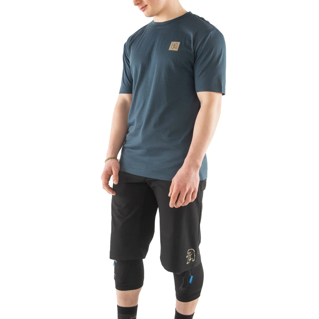 Person wearing a dark blue t-shirt and black athletic shorts on a white background