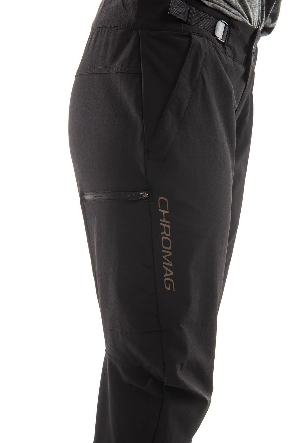 Close-up side view of black outdoor pants with a zippered pocket and vertical CHROMAG branding on the lower leg, shown against a white background.