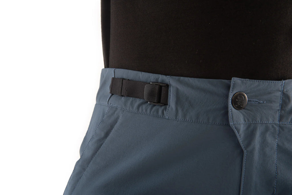 Close-up of blue pants with a black belt and button on a white background