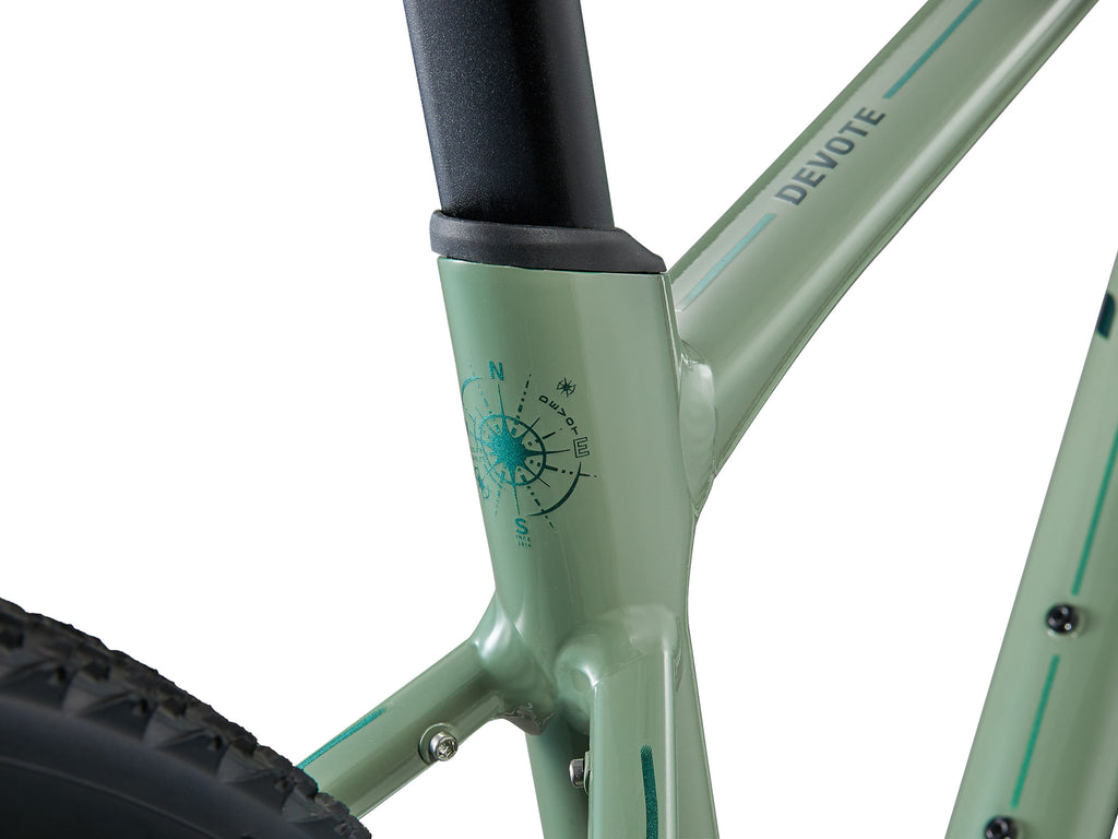 Close-up of a light green bicycle frame with 'Devote' branding on a white background