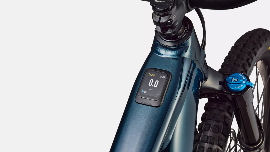 Close-up of a blue electric bike with a digital display on a white background