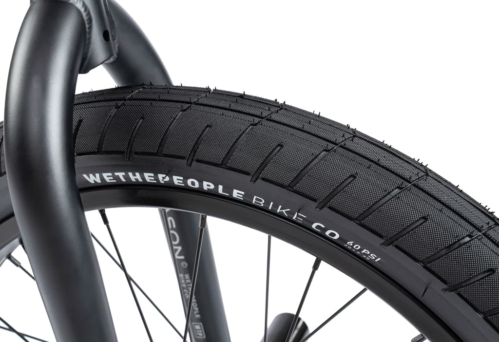 Close-up of a bicycle tire with 'Wethepeople Bike Co' branding on a white background
