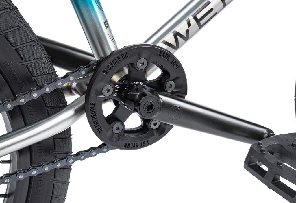Close-up of a bicycle chain and gear system with 'Wethepeople' branding