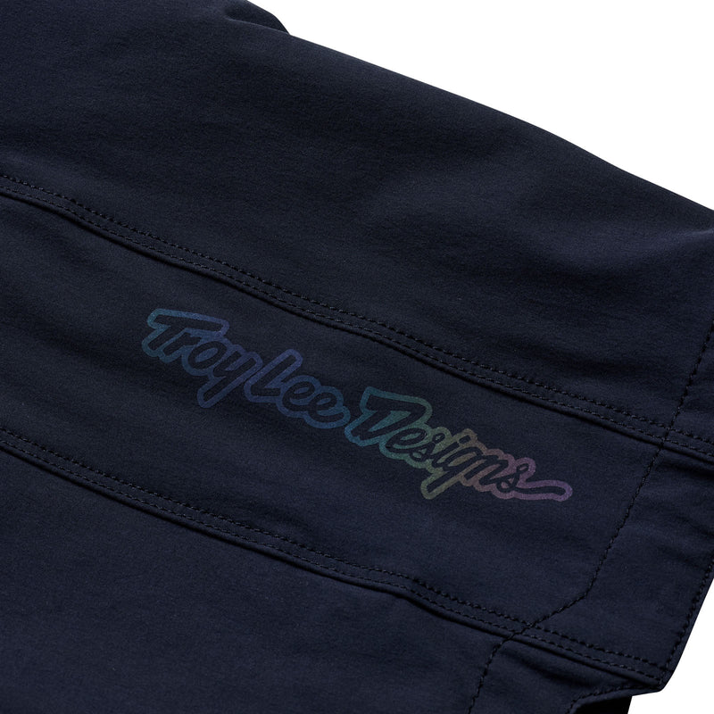 Close-up of a black garment with 'Troy Lee Designs' embroidery on a white background