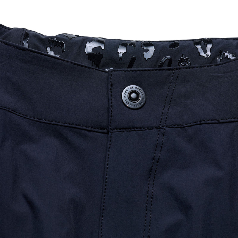 Close-up of a navy blue button on a garment with a brand logo.